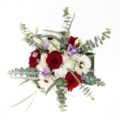 As you encounter this full-bodied bouquet, the distinct charm and refined balance strike you-qualities emblematic of Becontree Heath, where community and artistry intertwine. The bold, spiraled red roses stand as symbols of enduring affection at the center, while creamy white gerberas anchor the arrangement with their wide petals and inviting, brown-rimmed centers. Lilac-tinged lisianthus, some just beginning to unfurl, trace lines of gentle movement amidst the composition, reminiscent of soft twilight over Valence House Gardens. Soft clusters of ivory filler flowers envelop the arrangement in gentle fullness, creating a subtle layer of texture like morning mist on the Heath. Eucalyptus springs forth in elegant arcs, its silver-green leaves catching the light and lending subtle aromatic notes reminiscent of a walk through the local green spaces. Broad, dark leaves wrap the base with structure and polish-like the finishing touches a seasoned Becontree Heath florist would add before delivering a bouquet to a neighbour along Wood Lane. The transparent glass vase allows the viewer to admire the vivid freshness of each submerged green stem, emphasizing attention to detail and care. Whether chosen for heartfelt celebrations, as a gesture of remembrance, or to welcome new beginnings in homes throughout the area, this bouquet bridges artistic tradition and local warmth, reflecting the care and trust at the heart of Becontree Heath's floral craftsmanship.